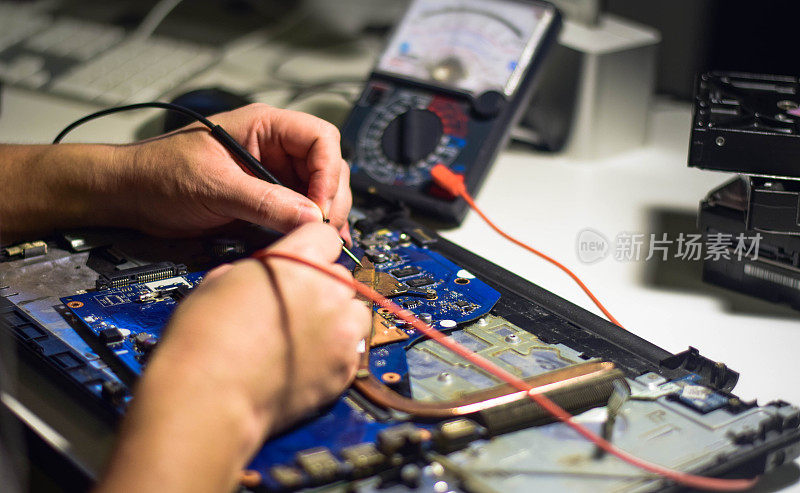 The repairman uses both hands and a meter cable to look for faults on the motherboard. Find the IC on the board that is hot or problematic on his desk.